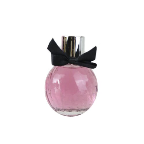 Bottle of La Madame Pour Femme by Dubai Essences, round design with pink liquid and a black bow on the neck of the cap.